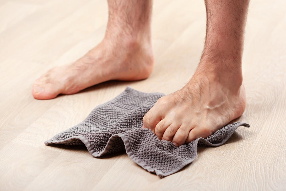 Using a towel for stretches for stiff toes